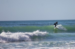 Aga riding down the face of a wave at Camel Beach